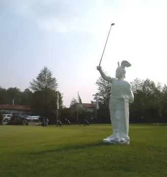 Hermannsdenkmal statue of a warrior holding a golf club on a manicured lawn.
