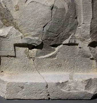 Çineköy inscription on a fractured stone block with carved ancient characters and relief designs.