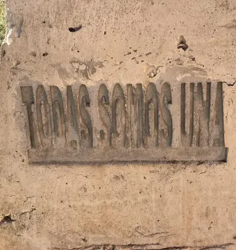 Close-up of the Antimonumenta showing the carved words “TODAS SOMOS UNA” on a weathered concrete panel.