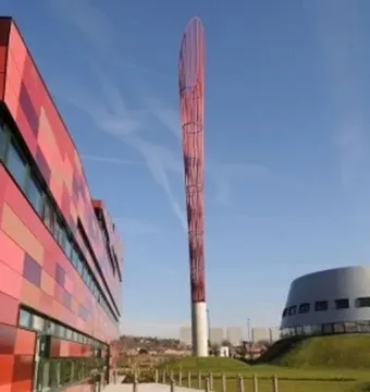Aspire sculpture rising above the University of Nottingham Innovation Park, with modern buildings on either side.