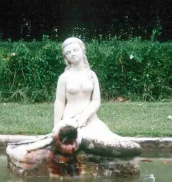 Mermaid Fountain statue of a mermaid sitting on a stone structure with water flowing into a basin