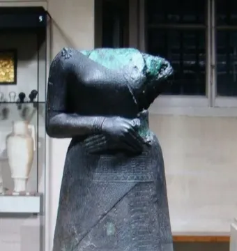 Headless Napir-Asu statue with a decorated skirt and clasped hands