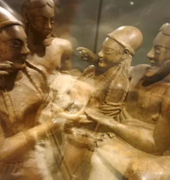 The Sarcophagus of the Spouses showing a reclining male and female figure with stylized features and blurred details.