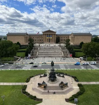 Bronze equestrian statue in front of the Philadelphia Museum of Art and terraced steps across a roadway.