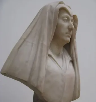 Bust of Camilla Barbadori in light-colored marble, showing a woman with a draped head covering and a dark pedestal.