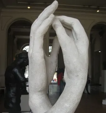 The Cathedral sculpture by Rodin, showing two raised hands forming an arch in a gallery.