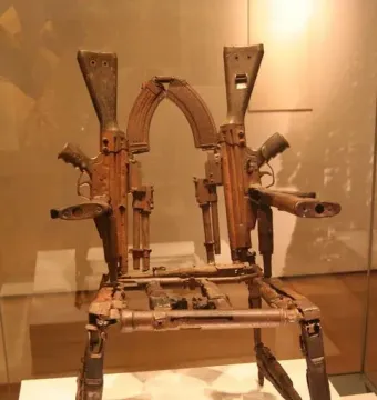 Throne of Weapons sculpture made from rusted gun parts and firearm components.