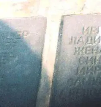 Two dark plaques on the Monument to the Victims of Fascism engraved with names in Cyrillic script.