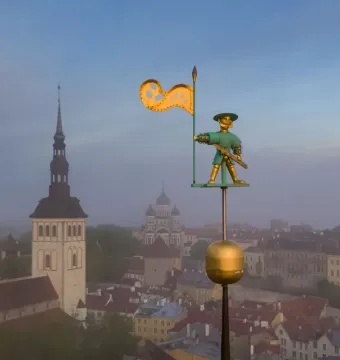 Old Thomas weather vane overlooking Tallinn’s old town skyline at dawn