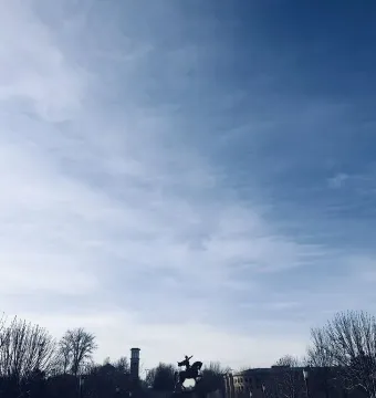 Timur equestrian statue silhouetted against a blue sky with wispy clouds.