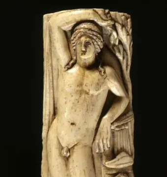 Apollino carved in relief, showing a nude male figure with one arm raised, a tree, drapery, and a lyre.