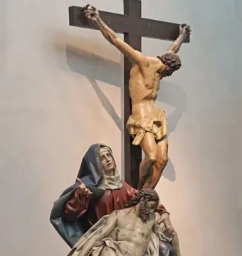Pietà sculpture showing Mary holding the lifeless body of Christ, with a crucifix figure above them