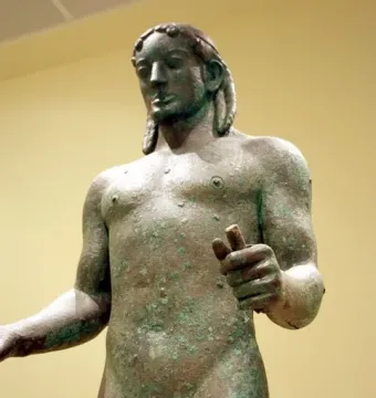 Detail of the Piraeus Apollo bronze statue with green patina and visible cracks.