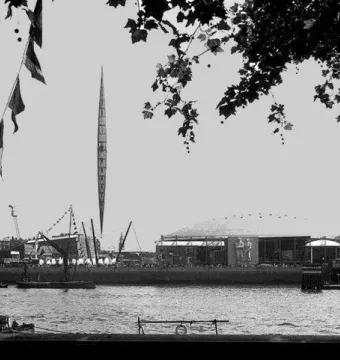 The Skylon, a tall slender pointed framework structure, rises against a bright sky.