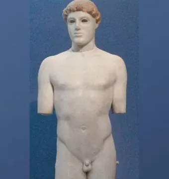 Kritios Boy marble statue of a nude young male figure against a blue background, missing its arms and part of one leg.