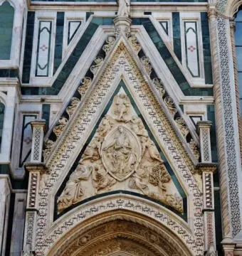 Porta della Mandorla tympanum with carved figures, mosaic detail, and patterned stone facade on Florence Cathedral