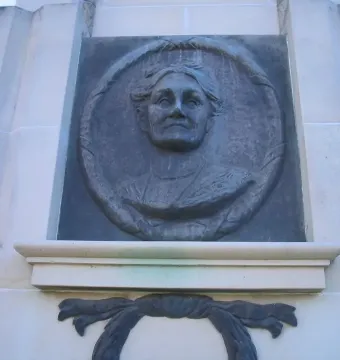 Edith Cowan Memorial relief bust set in a light stone structure with a circular frame and decorative draped element below.