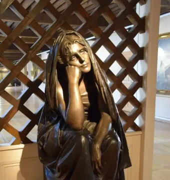 La Douleur bronze sculpture of a seated figure resting its chin on one hand