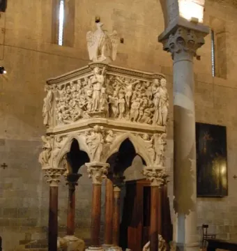 Sant\' Andrea Pulpit with carved figures and stone columns inside a church interior