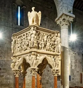 Sant\' Andrea Pulpit with carved marble figures, columns, and animal supports inside a stone church interior
