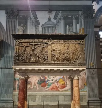 The Passion Pulpit bronze relief filled with figures inside a basilica interior.