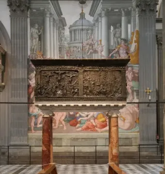 The Passion Pulpit, a dark bronze pulpit with densely carved relief panels and crucifixion scenes, set against a painted architectural backdrop.