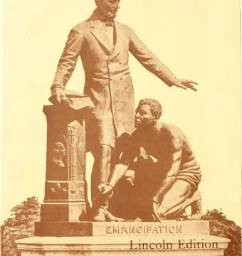 The Emancipation Memorial shows Abraham Lincoln standing with one arm extended beside a kneeling Black man with a broken chain on his wrist.