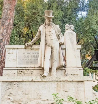 Monument to Giuseppe Gioachino Belli showing a stone statue of a man in a top hat and long coat on an ornate pedestal.