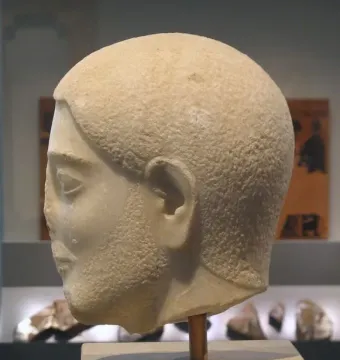 Sabouroff Head in light-colored stone, shown in profile facing left with textured hair and beard.