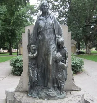Pioneer Mother Memorial sculpture of a robed figure on a stone base with three smaller figures at her feet.