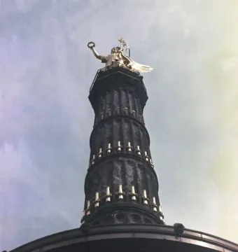 Victory Column seen from below, with a golden winged statue on top of the column.