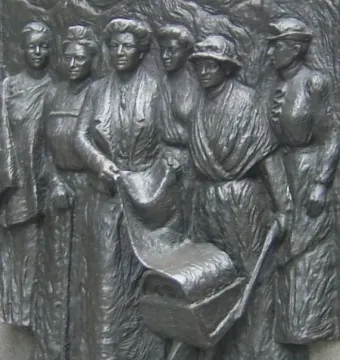 Close-up of the Kate Sheppard National Memorial bronze relief showing women in period clothing around a scroll and small wheeled cart.