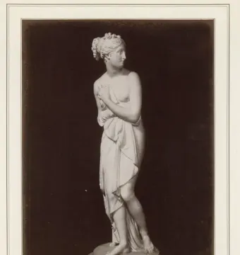 Venus Italica standing marble statue with draped cloth, turned to the right on a round pedestal.