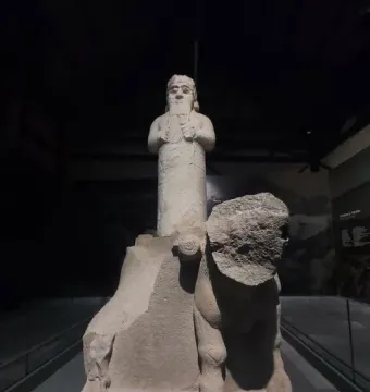 Çineköy inscription stone sculpture with a standing bearded figure and a damaged animal relief at the base