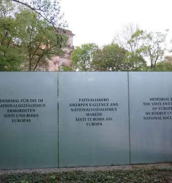 Frosted glass wall of the Memorial to the Murdered Sinti and Roma of Europe with memorial text in German, Romani, and English.