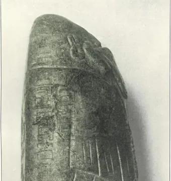 Left side of the Tuxtla Statuette showing carved glyph columns and a stylized face near the top.
