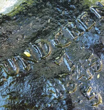 Close-up of Morianbron showing an inscribed dark stone with the name Lundgren and the dates 1745 and 1845.