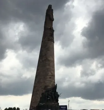 The Roundabout of the Disappeared stone monument rising above a circular base covered with banners and signs.