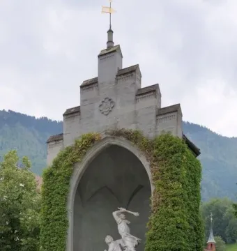 Winkelried Memorial in Stans, a tall stone monument with an arched niche holding a white marble sculpture.