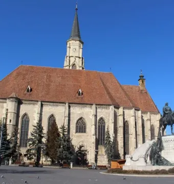 Matthias Corvinus Monument with a bronze equestrian statue and accompanying bronze figures in front of a stone church.