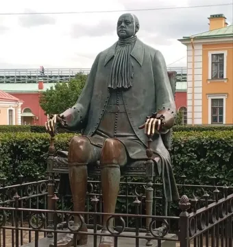 Peter I Monument showing a bronze seated figure on a throne behind a decorative fence.