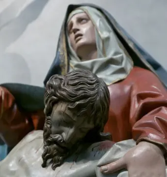 Close-up of the Pietà sculpture showing Mary supporting the lifeless body of Christ.