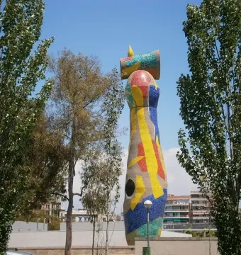 Dona i Ocell, a towering abstract mosaic sculpture with red, yellow, and blue tiles in Barcelona.