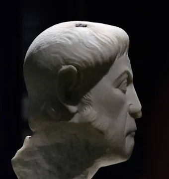 White marble bust of Eutropius in profile facing right, with short wavy hair, a beard, and a prominent nose.