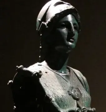 Upper portion of Minerva d\'Arezzo showing a helmeted female figure with a scaly chestplate and a small head relief on the aegis.