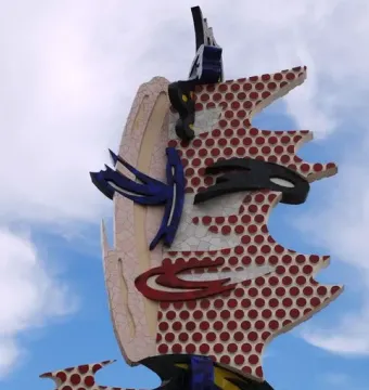 The Face of Barcelona sculpture with a stylized face in cracked mosaic and red polka dots.