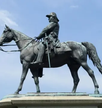 Winfield Scott equestrian statue in bronze against a blue sky with scattered clouds.