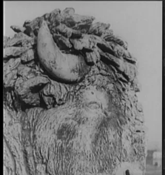 Close-up profile of a sculpted bison head with shaggy fur and a single visible horn.