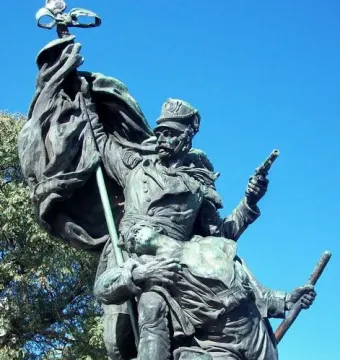José de San Martín equestrian statue with a bronze military figure holding a flag and pistol beside other figures