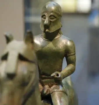 Bronze Armento Rider statuette of an armored warrior on horseback, shown in close-up with the horse’s head blurred in the foreground.